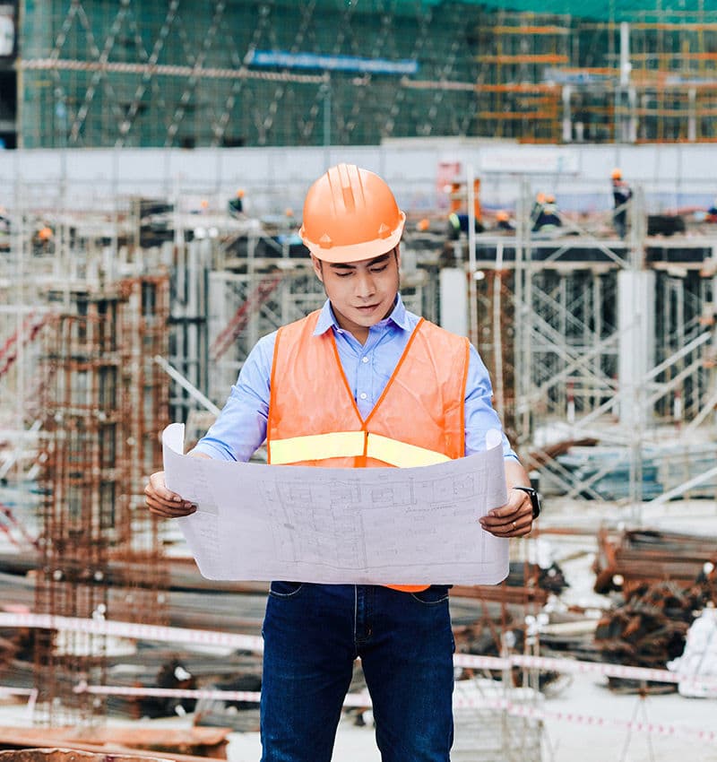 Engineer with blueprints on construction site